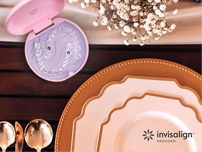 The image shows a collection of tableware items including plates, bowls, and a lid, set against a backdrop with a pink box and a spoon.